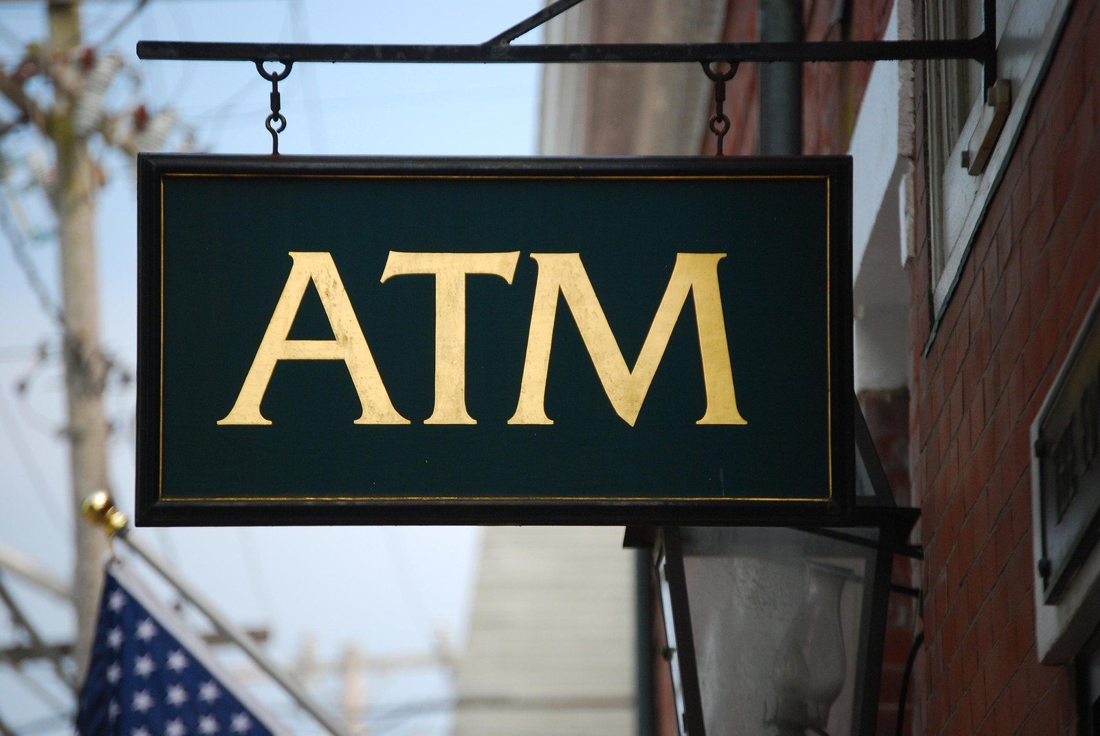 ATM sign hanging over a street