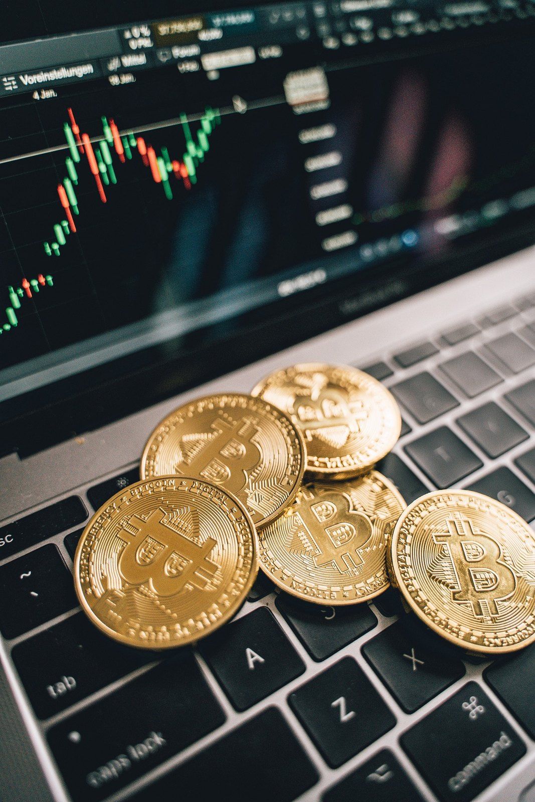 Laptop with a price chart and bitcoin coins